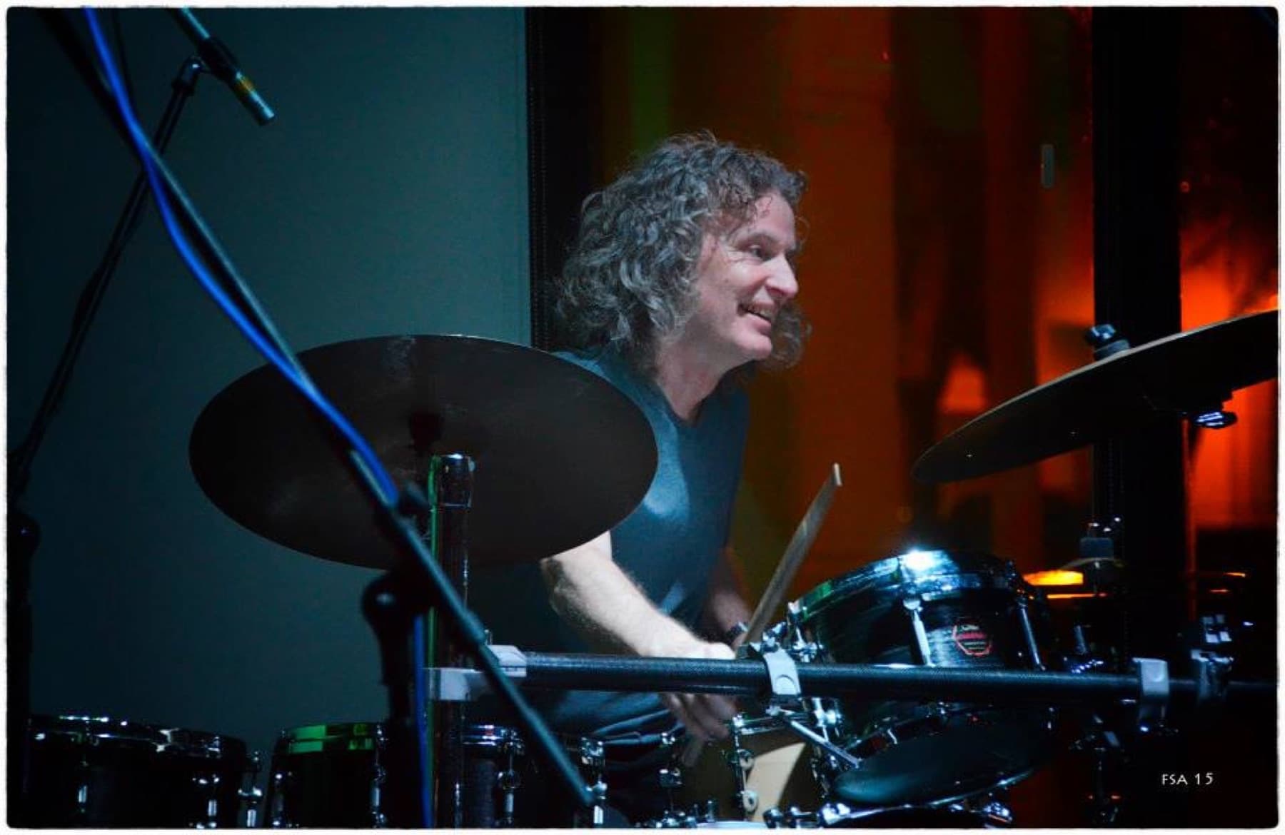 Steve Rucker seen past a cymbal at the drum kit